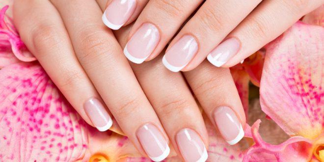 French Manicure mit Blüten im Hintergrund