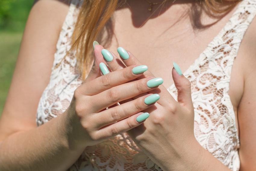 Frau mit pastellblauen Fingernägeln