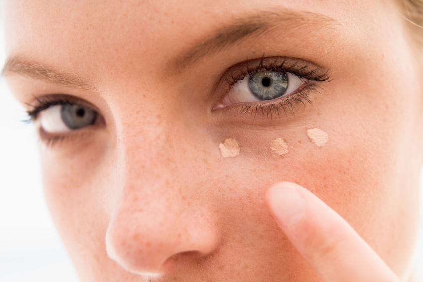 Frau legt Concealer auf für natürliches Make-up