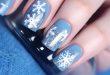 Nägel mit Schneeflocken und blauem Hintergrund