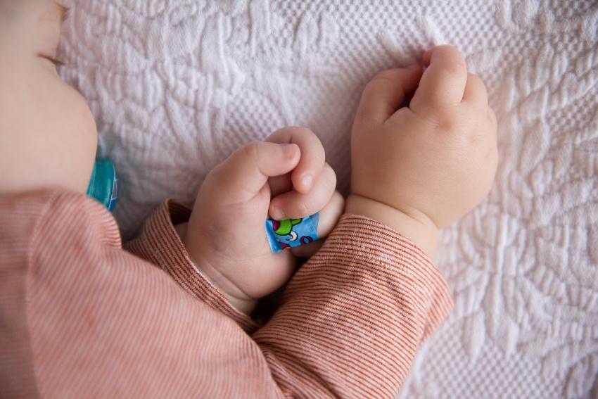 Baby schläft, Heftpflaster am Ringfinger - Ab wann Nägel schneiden bei Babys?