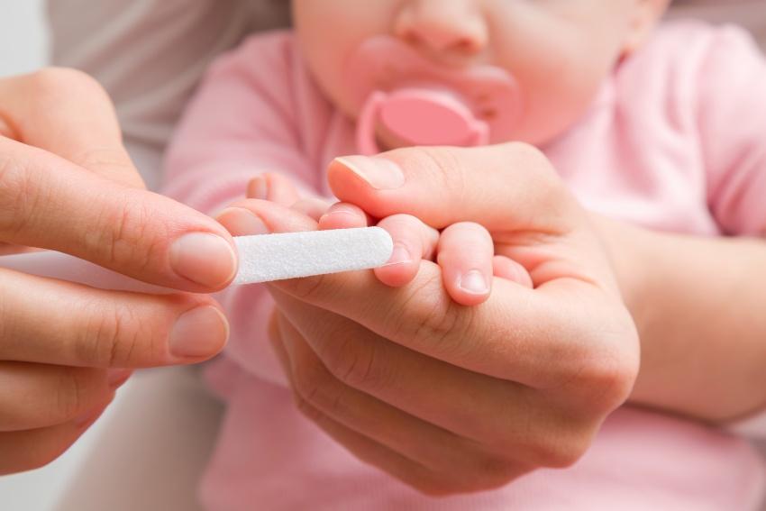 Mutter feilt Fingernaegel eines Babys - Ab wann Nägel schneiden bei Babys?