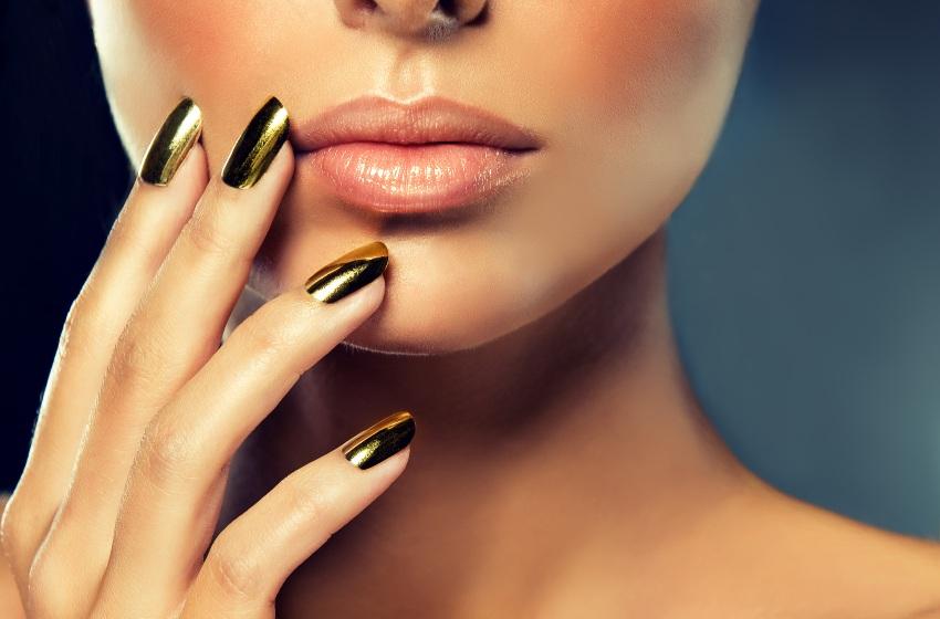 Frau-mit-goldfarbenen-Finernaegeln - Metallic Nails